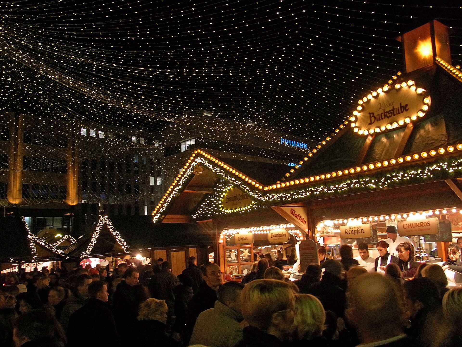 Beleuchtete Buden und Lichterhimmel auf dem Essener Weihnachtsmarkt am Abend