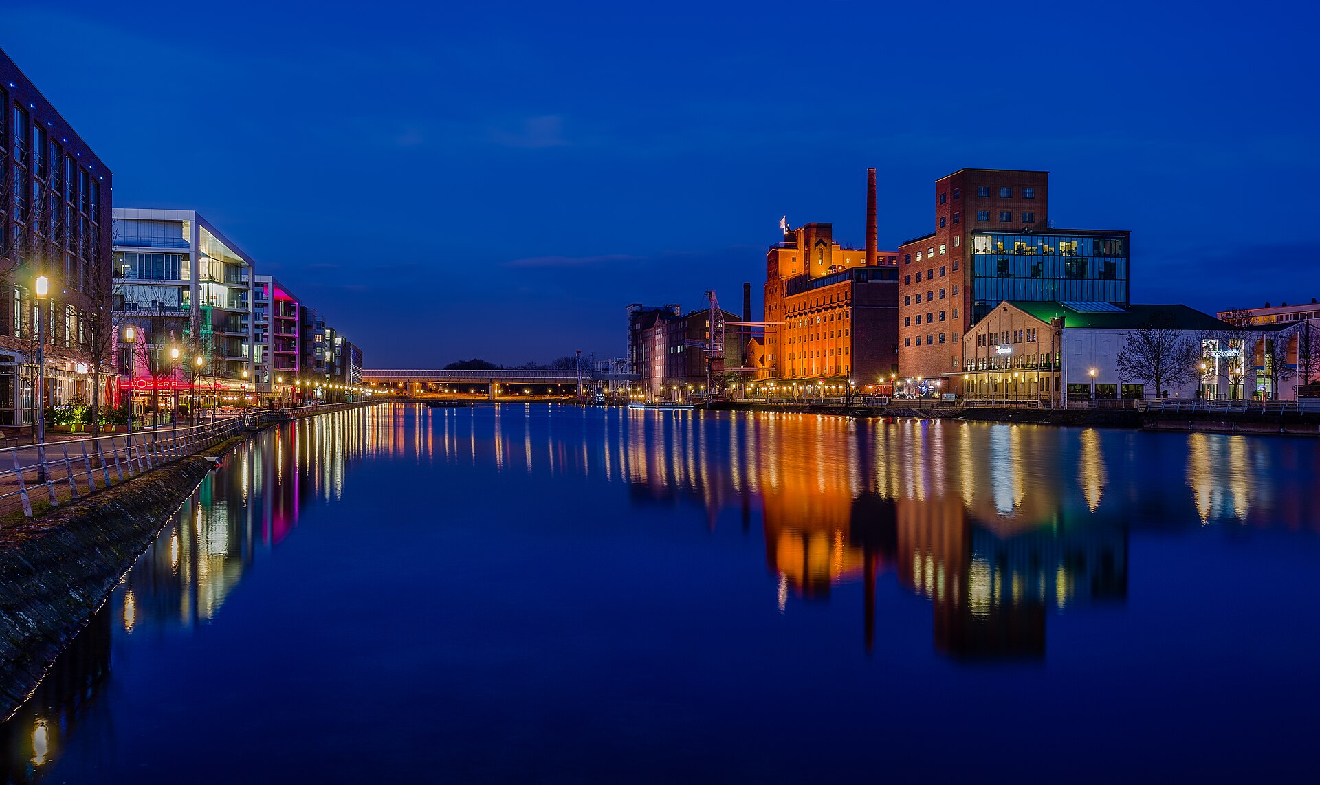 Innenhafen Duisburg mit beleuchteten Gebäuden am Wasser am Abend