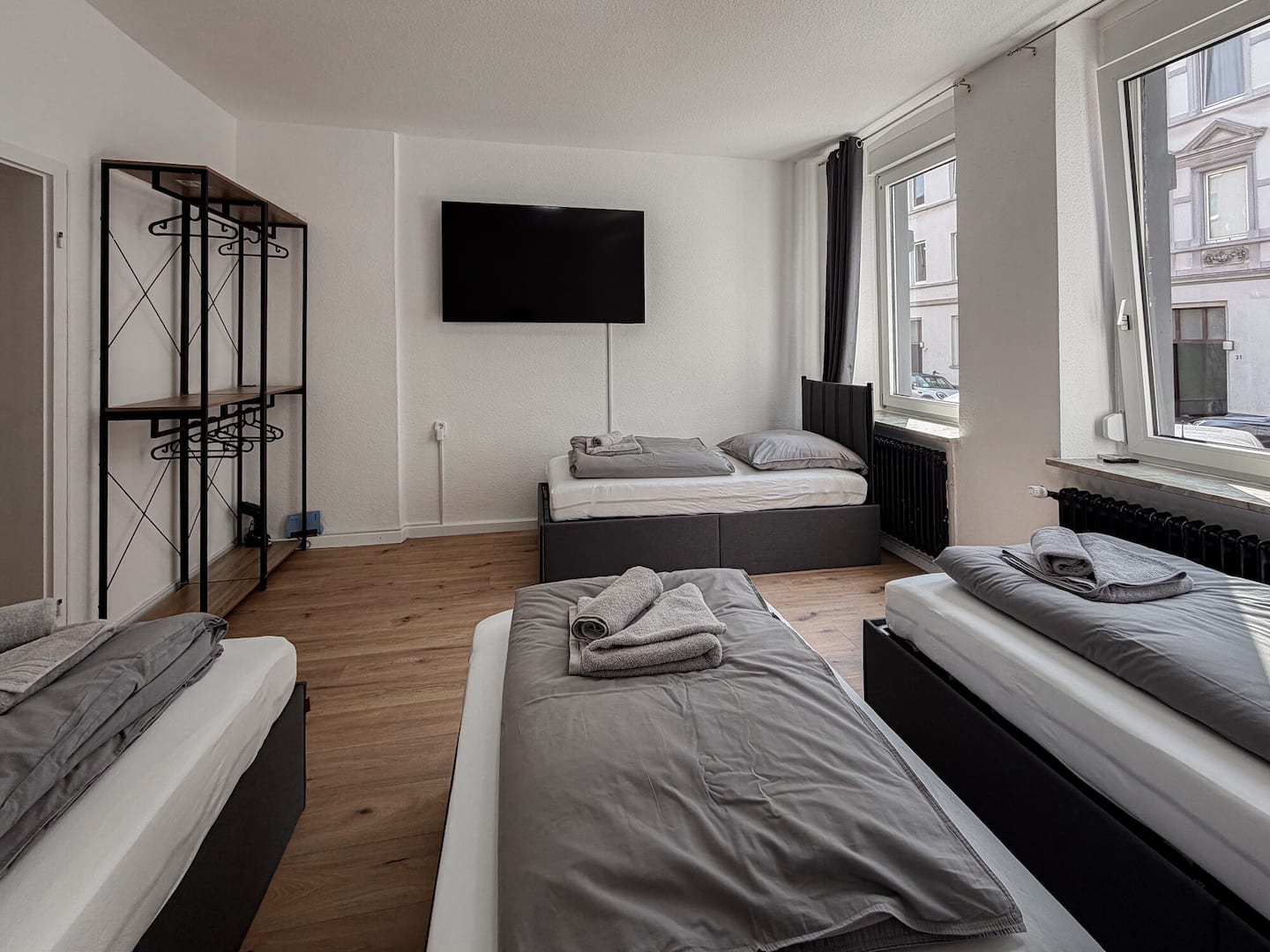 Wohnschlafraum mit 65-Zoll-Fernseher und Kleiderständer im Apartment Frida in Essen